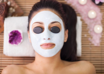  relaxed woman receiving stone therapy in spa