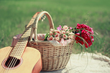 Fototapeta na wymiar Guitar, basket and bouquet of flowers. Vintage tender background