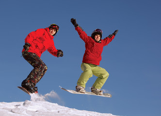 Two snowboarder jumping