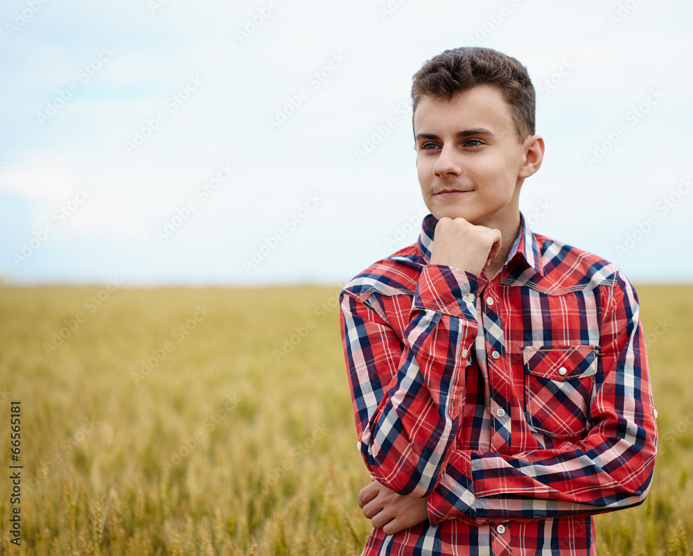 Wall mural teenage boy in a wheat field