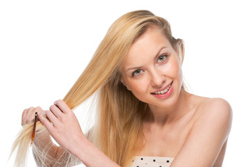 Happy young woman combing hair