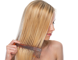 Young woman combing hair