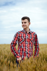 Naklejka na ściany i meble Teenage boy in a wheat field