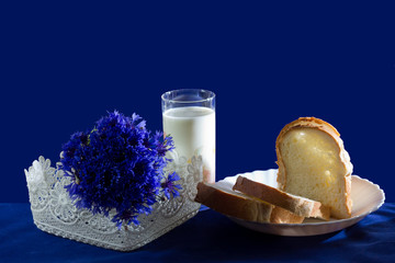 A glass of milk with bread and cornflowers