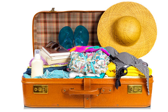 Packed vintage suitcase full of vacation items.