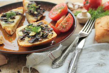 Rasted bread with mushrooms, cheese and garlic on a plate