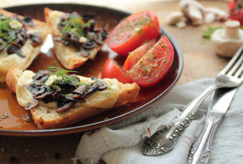 Plate with bruschetta with mushrooms, cheese and garlic