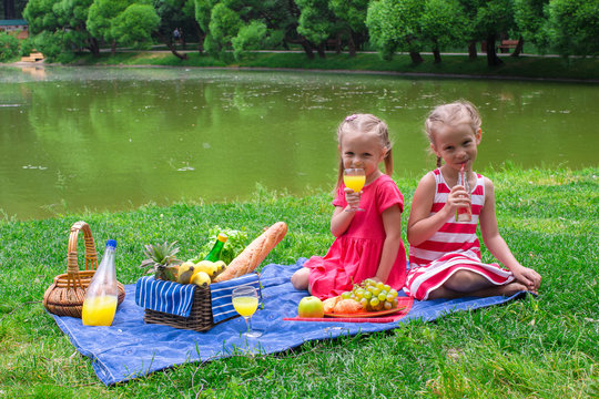 Adorable little kids picnicing in the park at sunny day