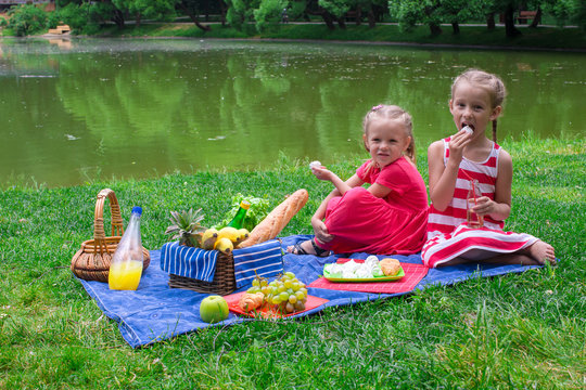 Cute little girls picnicing in the park at sunny day