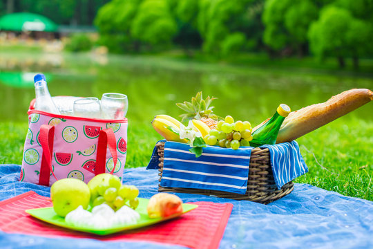 Picnic basket with fruits, bread and bottle of white wine