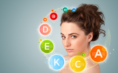 Pretty young girl with colorful vitamin icons and symbols