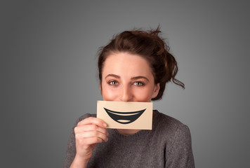Happy pretty woman holding card with funny smiley