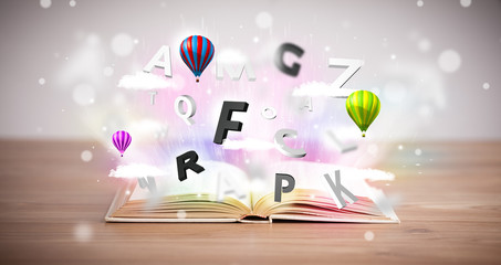 Open book with flying 3d letters on concrete background
