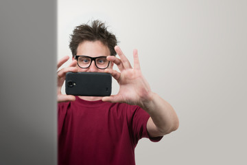 Man in glasses photographed by smartphone