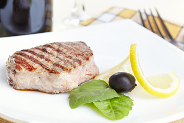 Grilled steak on white plate closeup