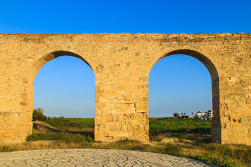 Old Greek aqueduct in warm sunset light in Larnaca, Cyprus