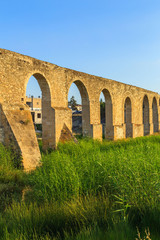 Fototapeta na wymiar Old Greek aqueduct in warm sunset light in Larnaca, Cyprus
