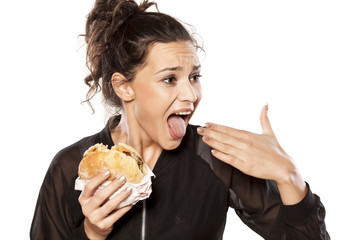 Young woman with spicy sandwich and burning tongue