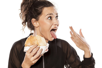 Young woman with spicy sandwich and burning tongue