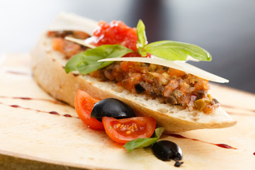 Italian appetizer bruschetta with tomato, basil and black olives