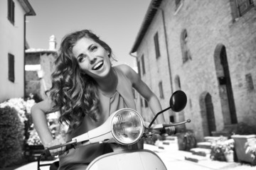 Fototapeta premium beautiful italian woman sitting on a italian scooter.