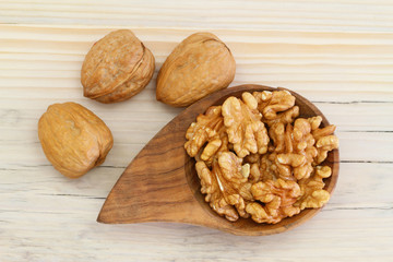 Walnuts with and without shell on wooden background