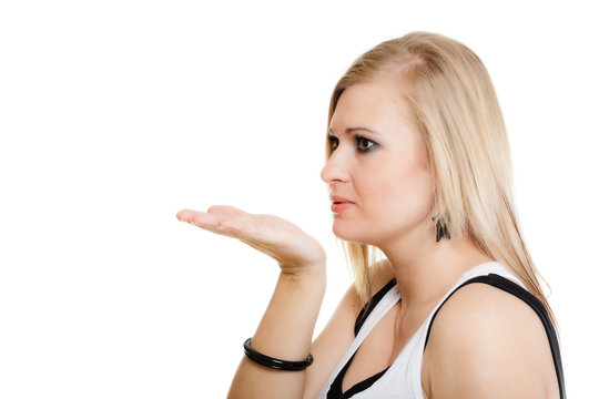 Blonde girl blowing a kiss or with copy space on hand