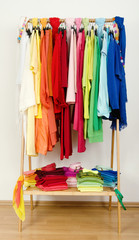 Wardrobe with colorful summer clothes and accessories on hangers