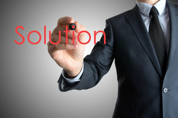 business man writing solution concept on grey background