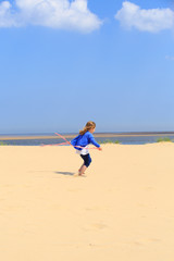 Fototapeta na wymiar Young girl jumping on a sandy beach