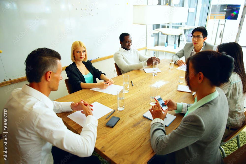 Wall mural Businesspeople having meeting around table in office