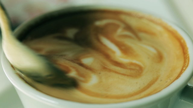 Coffe mixing by a spoon, closeup