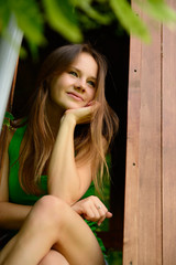 outdoor portrait of cheerful attractive teen girl in garden wood