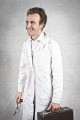 Young doctor on wall background