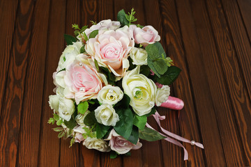 Wedding bouquet from white and pink roses on wooden background.