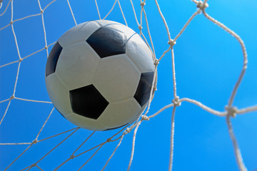 Soccer ball in goal and blue sky