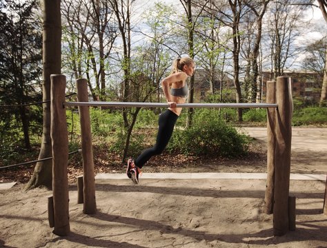 Fitness female doing parallel bar dips