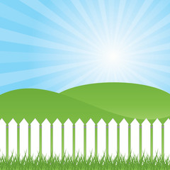 White fence and green grass on blue sky background