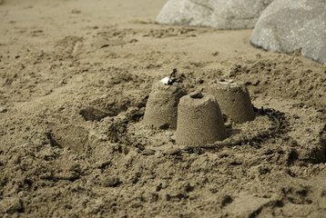 Three Simple Sandcastles on Beach
