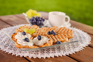 Sweet breakfast on wooden table in the garden