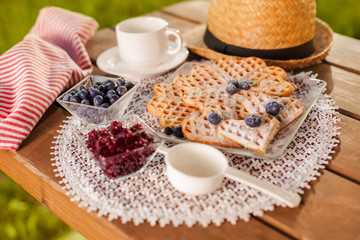 Summer snacks on wooden table in the garden