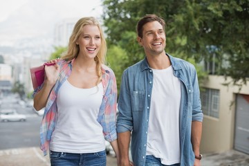 Obraz premium Hip young couple on shopping trip walking uphill