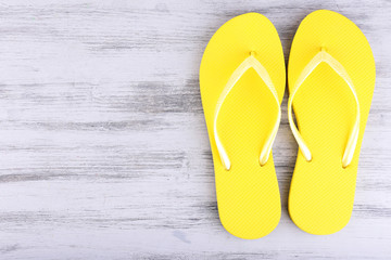 Bright flip-flops on color wooden background