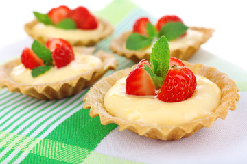 Tasty tartlets with strawberries on table close-up