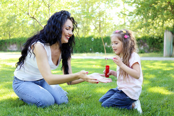 Happy mom and daughter. Walk in the green park