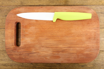 Kitchen knife and cutting board on wooden table