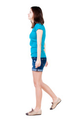 back view of walking  woman in shorts.