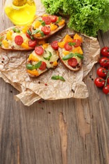 Tasty bruschetta with tomatoes, on old wooden table