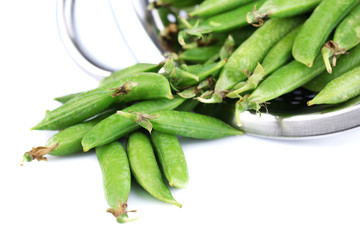 Fresh green peas in colander isolated on white background