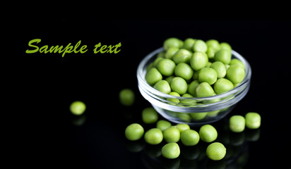 Fresh green peas in bowl isolated on black background